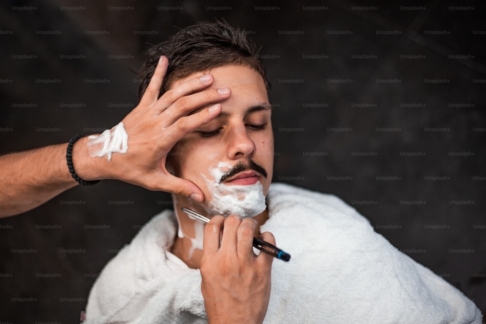 Man mith mustaches having a shave
