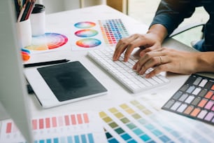 Freelance creative designers working on desk in modern home office.