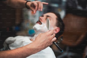 Man mith mustaches having a shave