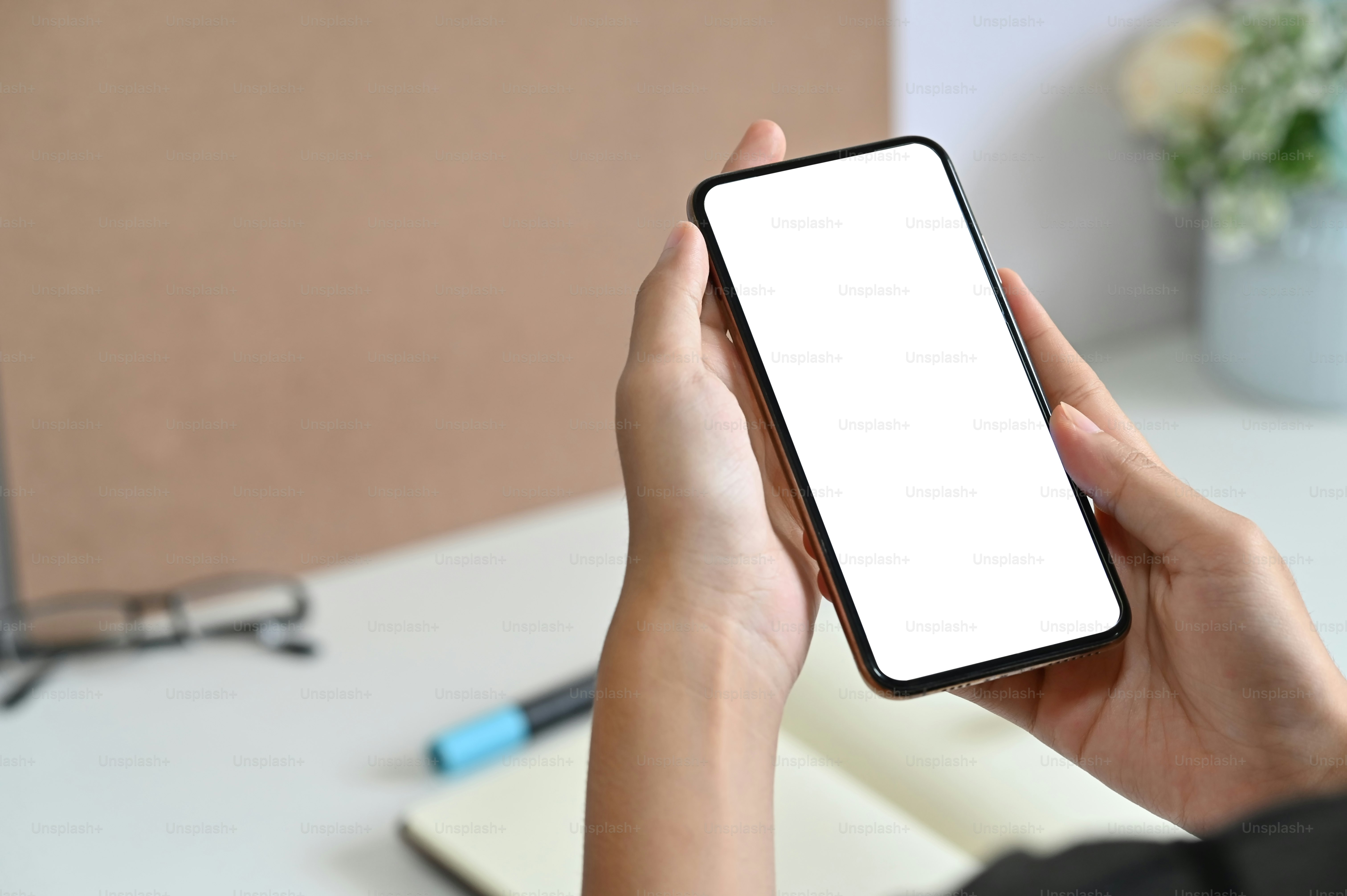 Recadré photographié femme à l’aide d’une maquette de smartphone sur un bureau.