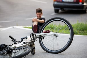 Teenage boy There is a knee injury, as the bike falls while riding. Kid hurt his leg after falling off his bicycle