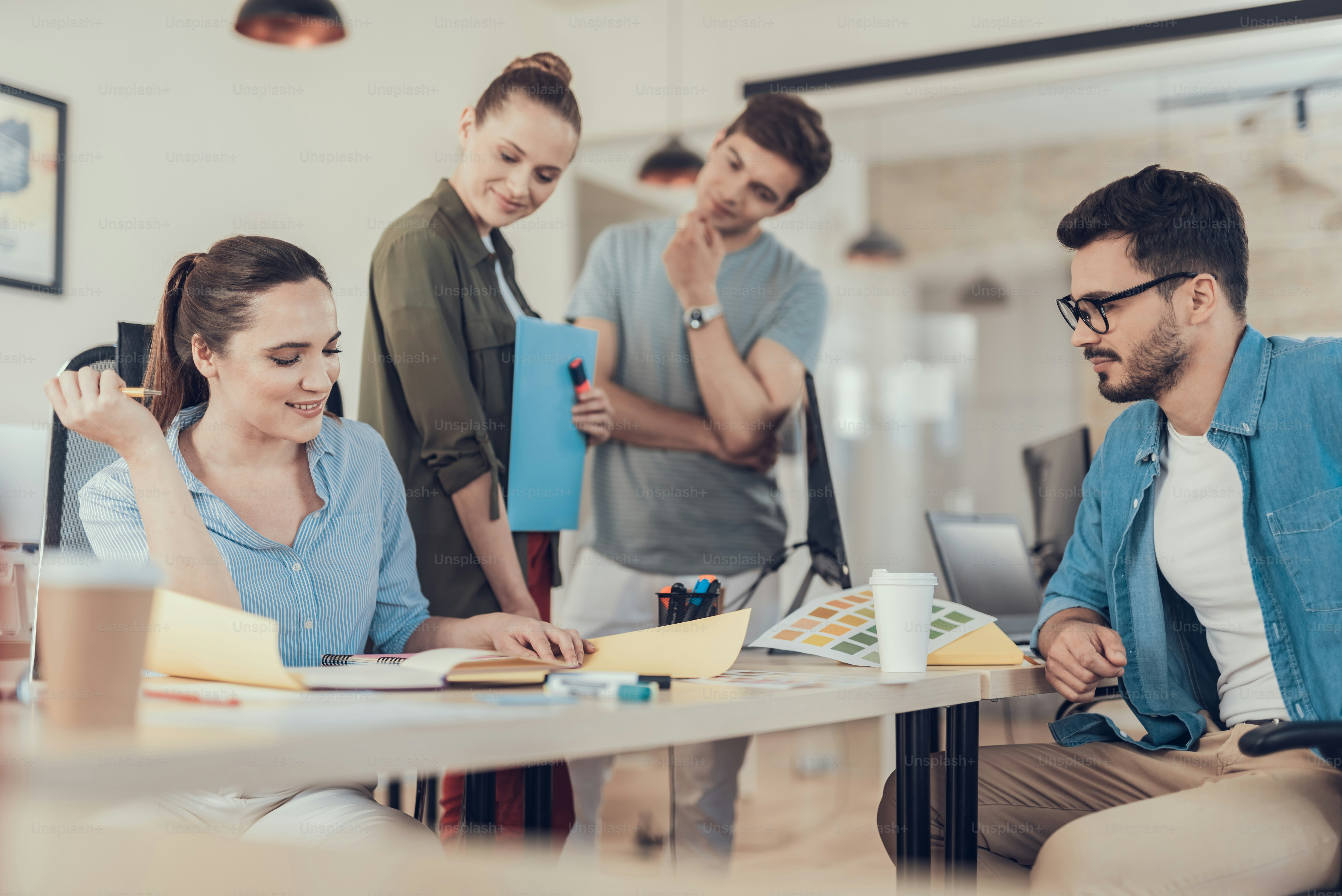 Porträt von Männern und Frauen, die am Schreibtisch sitzen und über ein neues Projekt debattieren