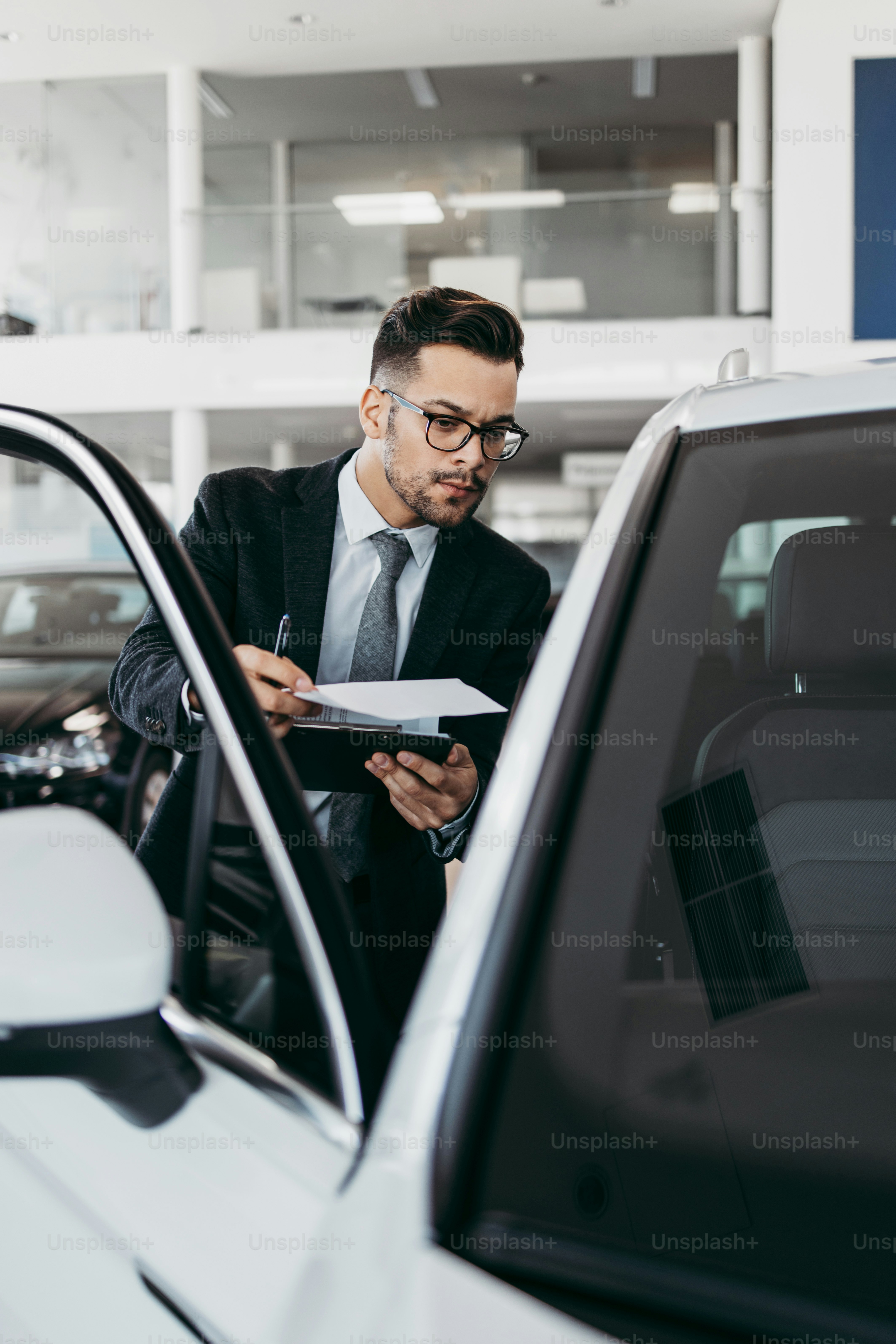 Car seller working in showroom and quality control checking of car details for the last time before buyer comes.