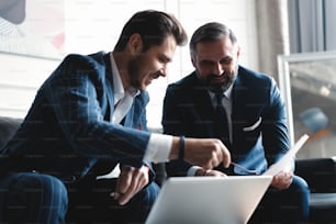 Business executives discussing work, developing strategy for online business, explaining sharing ideas, preparing presentation, having brainstorming session at office.