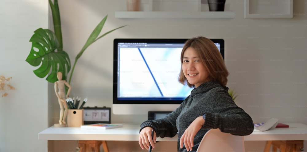 Freelancer asiática segura de sí misma en el escritorio de su espacio de trabajo