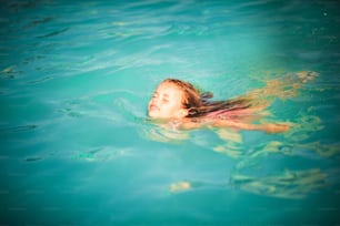 Swimming as a recreation. Child swimming in the pool.