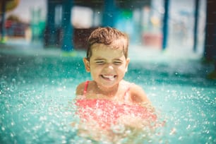 Happy day. Smiling little girl playing in the pool.