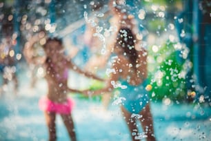 Day for friends. Two child playing in the pool. Focus is on drops.