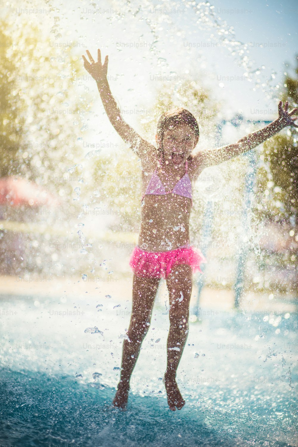 Drops of water is fun. Child having fun in the pool.