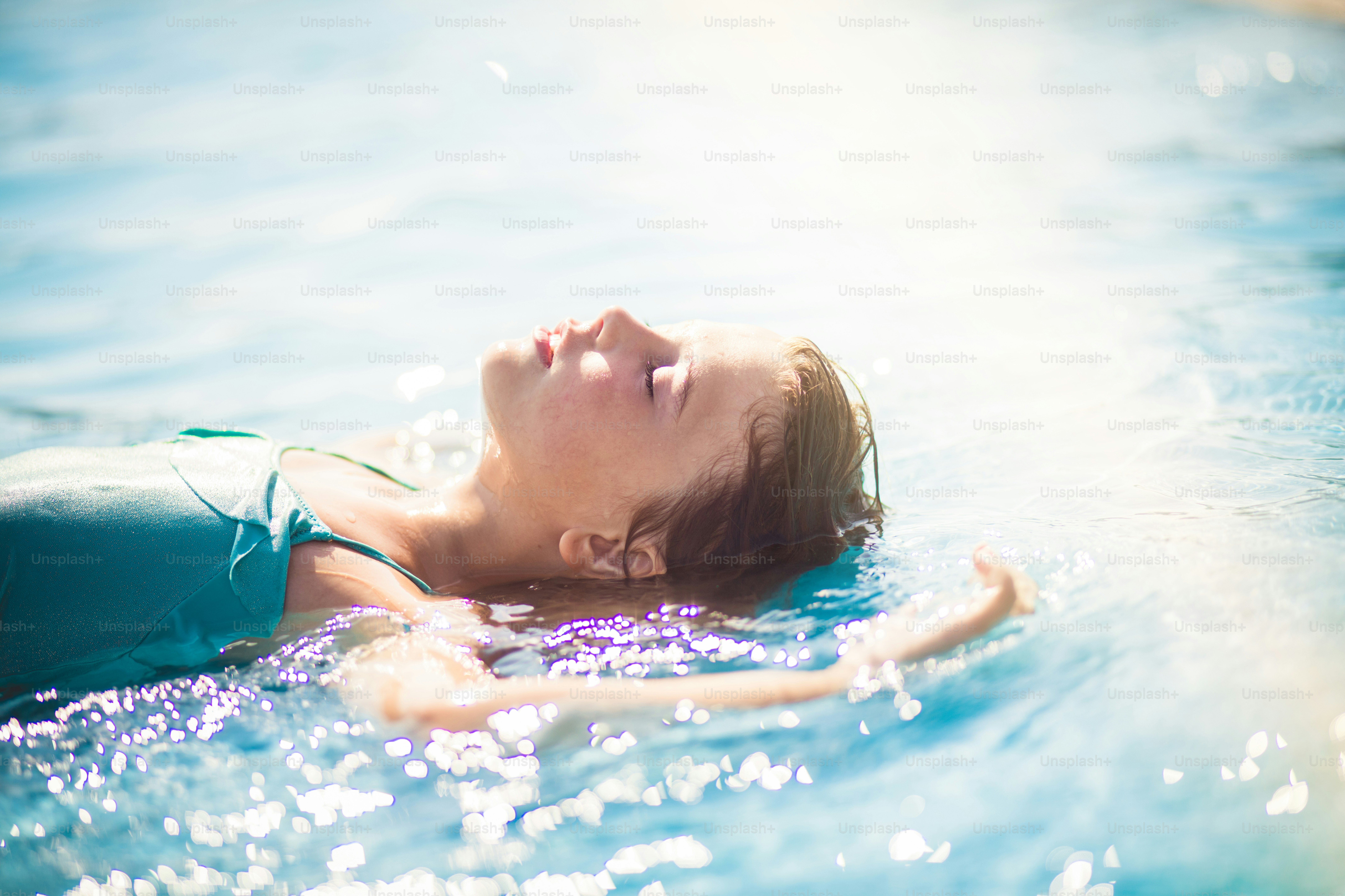 Der Sommer ist die Erfrischungszeit. Kind liegt im Pool.