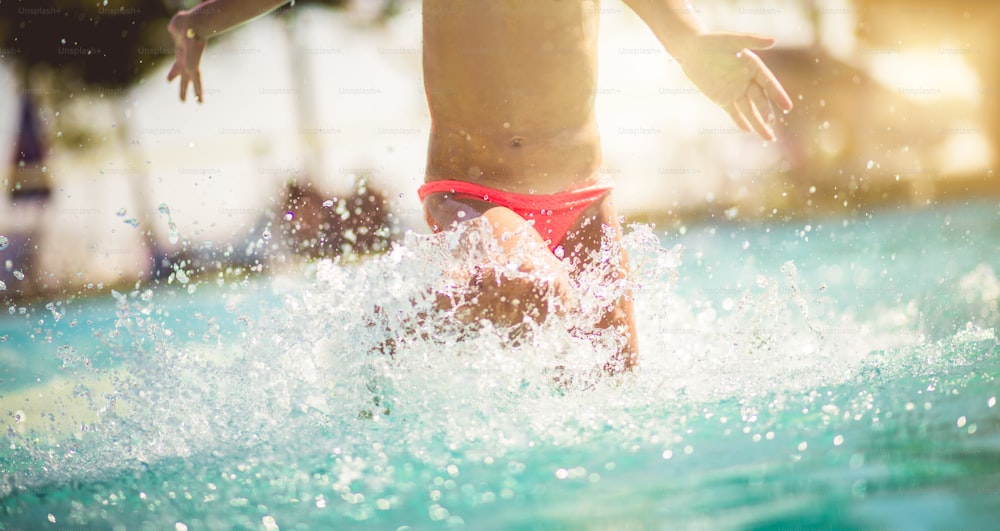 Quando é verão, é divertido todos os dias. Criança na piscina.