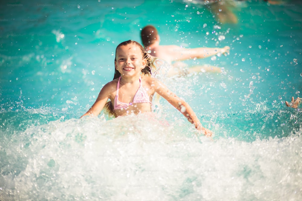 These waves are wonderful. Child having fun in the pool.