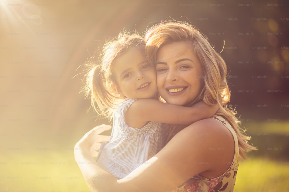 My favorite place is inside your hug. Mother and daughter in nature.