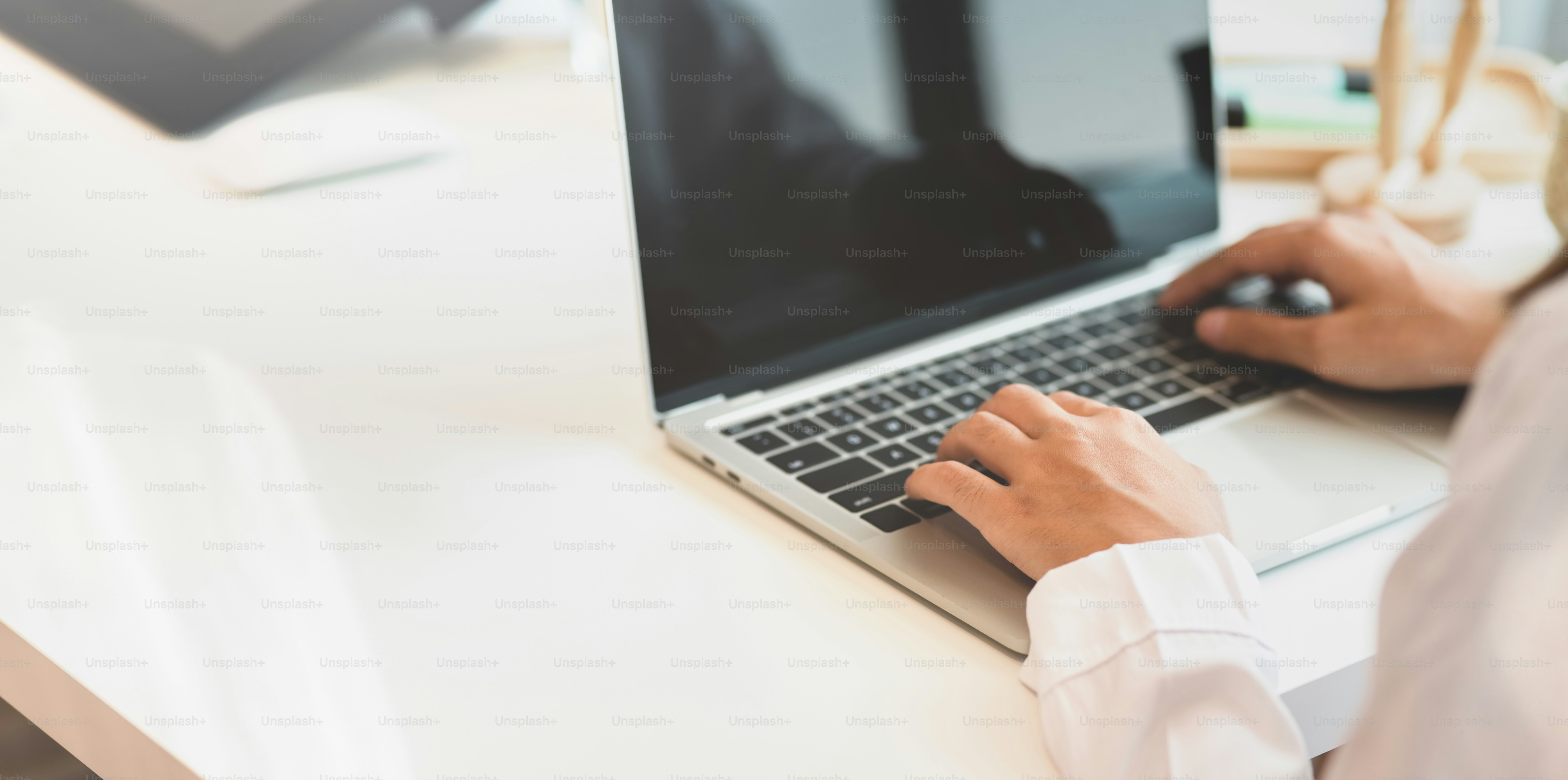 흐릿한 배경으로 최소한의 작업장에서 노트북으로 작업하는 젊은 여성 프리랜서