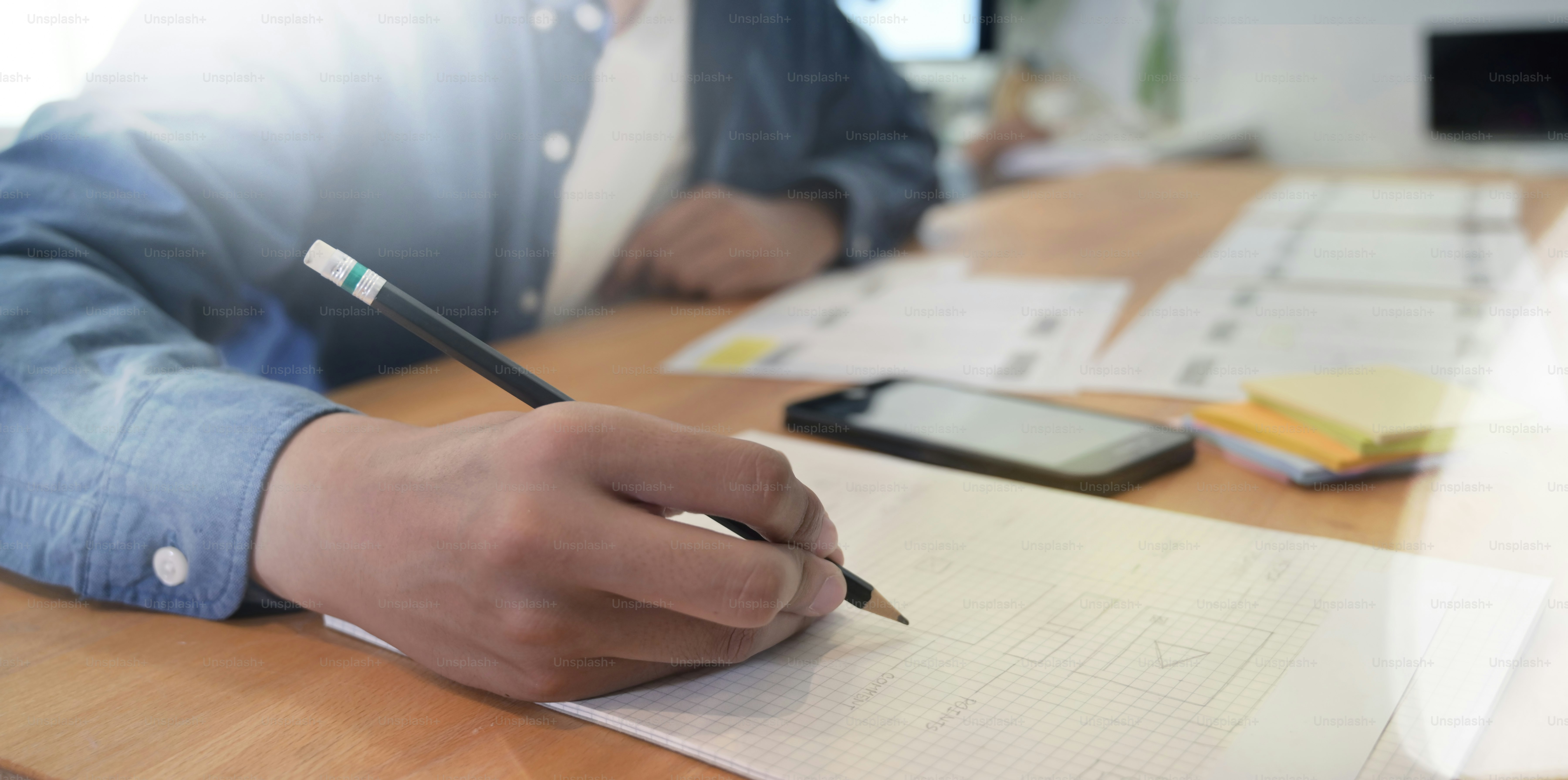 Close-up view of UI Designer drawing website UX app development in modern office