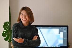 Happy woman working, Female creative artist looking at camera in stylish office.