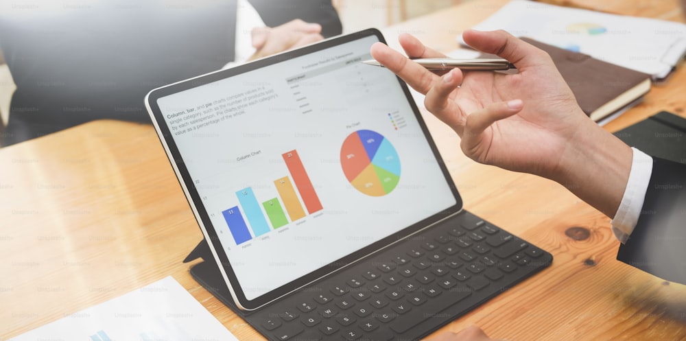 Close-up of successful business team planing the strategy with graphs and charts with tablet on modern office room