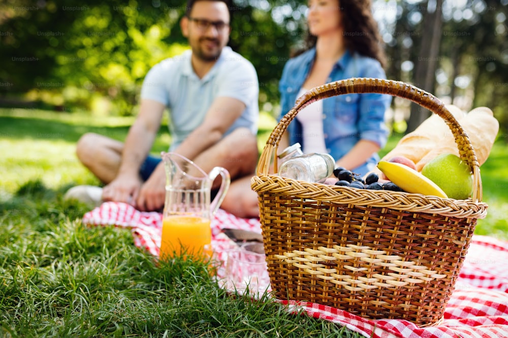 Happy young couple enjoying picnic in park outdoor