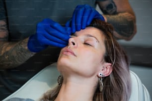 Man showing a process of piercing with steril medical equipment and latex gloves. Marking the piercing spot. Body Piercing Procedure