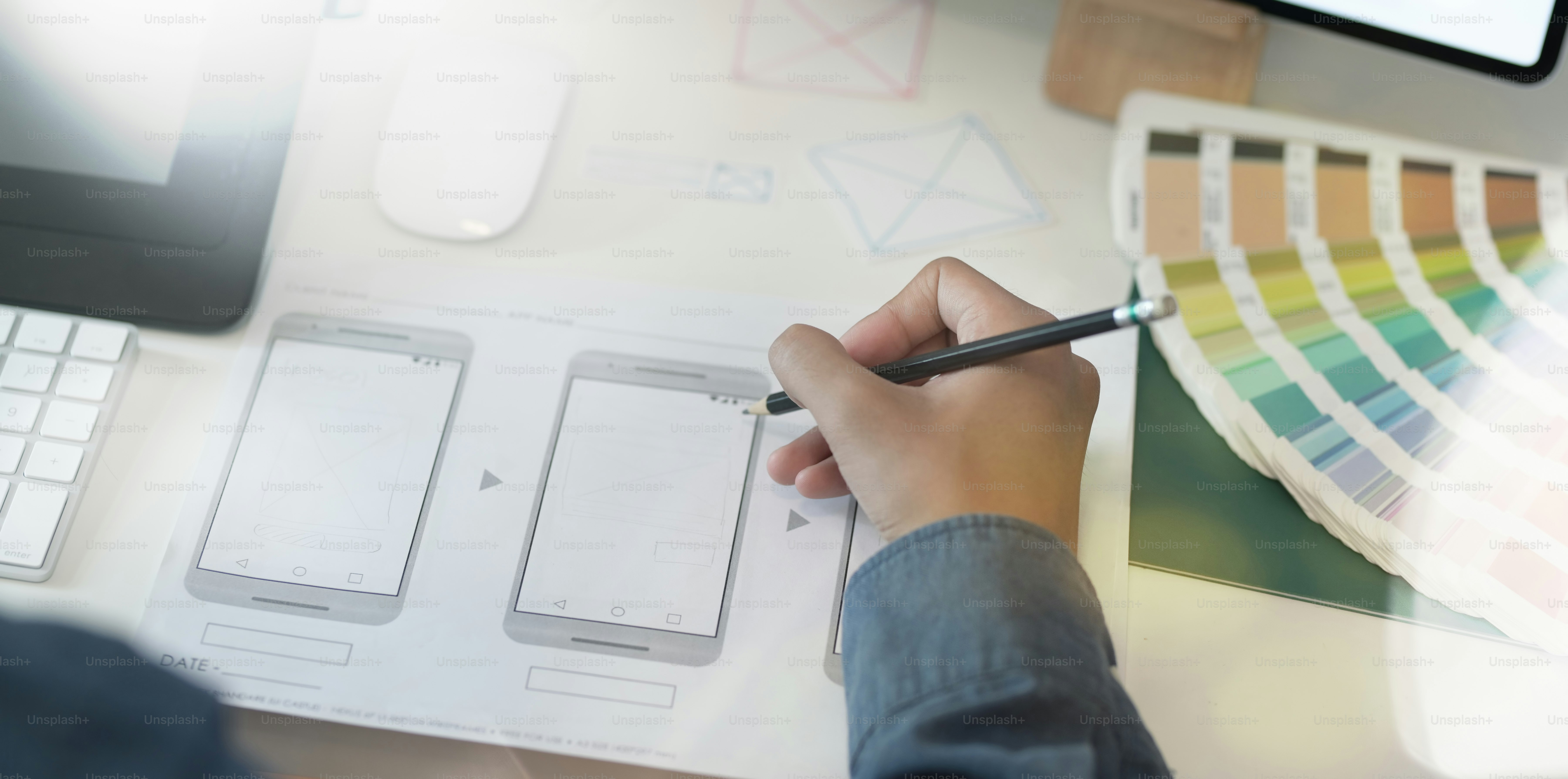 Close-up of UI UX graphic designer drawing smartphone template for his new project