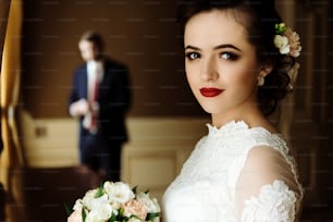 stylish luxury bride and handsome elegant groom  on the background of rich interior in old building