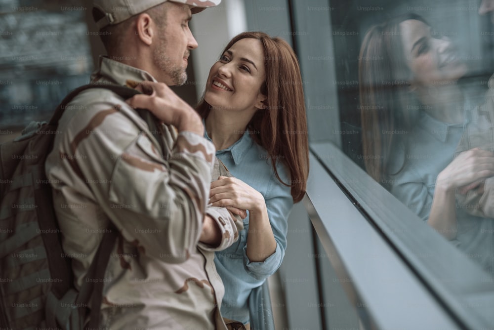 Taille d’une belle femme caucasienne souriant à un soldat américain. Copiez l’espace sur le côté droit. Concept militaire
