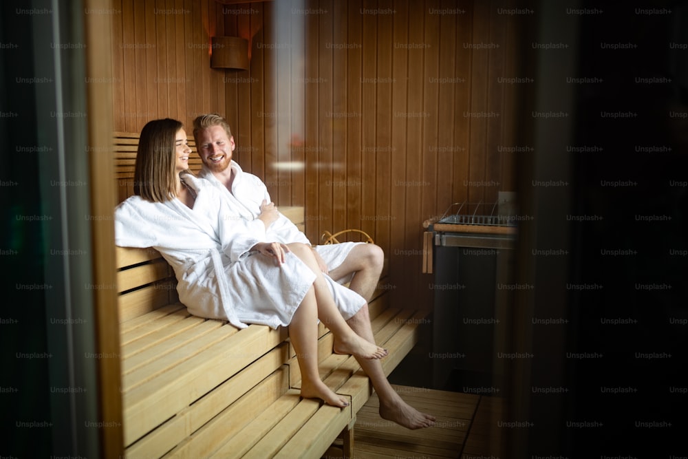 Beautiful people in bathrobes using sauna at spa resort