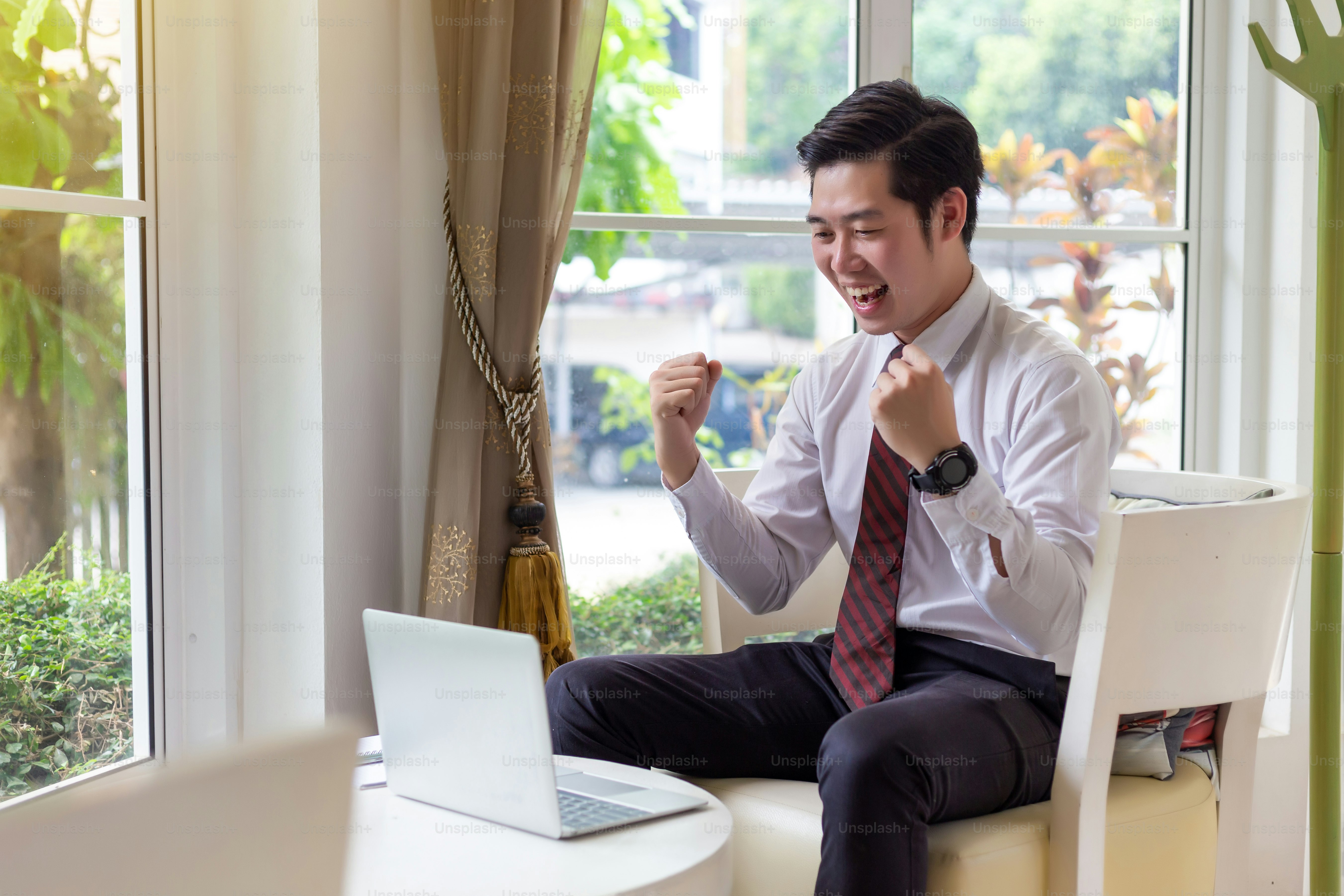 Happy young businessman is working on laptop.