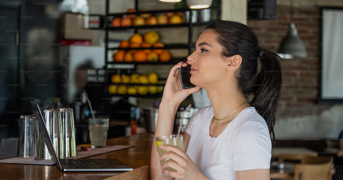 Calling Alone Young charming woman calling with cell telephone while sitting alone in ...