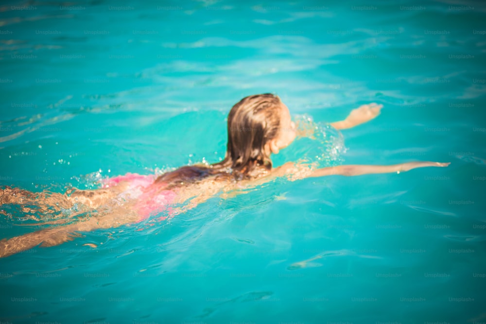 Like a mermaid. Little girl swimming in the pool.
