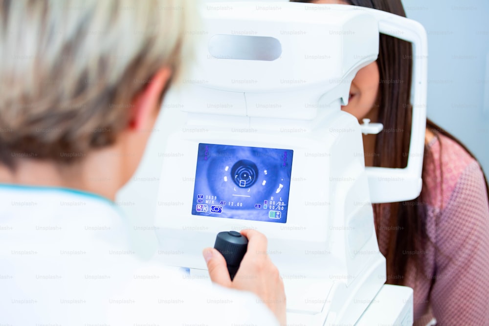 Une femme médecin ophtalmologiste vérifie la vision oculaire d’une jeune femme attrayante dans une clinique moderne. Médecin et patient en clinique d’ophtalmologie