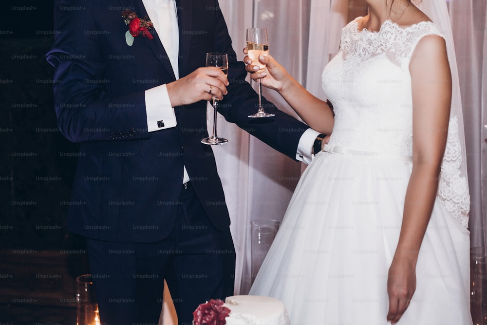 bride and groom toasting with champagne glasses at wedding ceremony reception, luxury catering