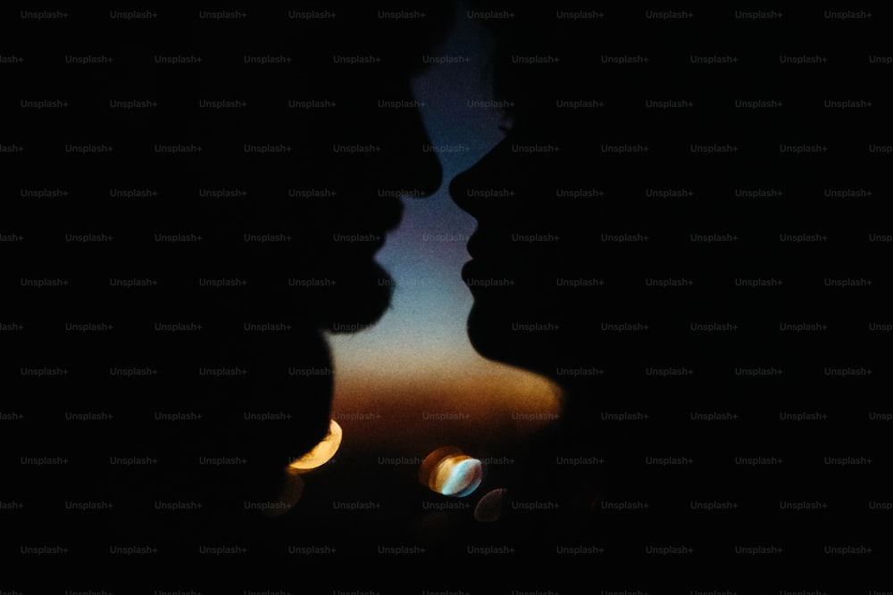 Silhouette des glücklichen Paares, das sich gegenseitig anschaut und sich mit sanftem Hintergrund des Sonnenuntergangshimmels und der Stadtlichter berührt