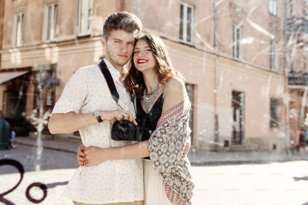 happy stylish couple taking selfie in a dirty mirror at old european city street, funny tender moment, space for text