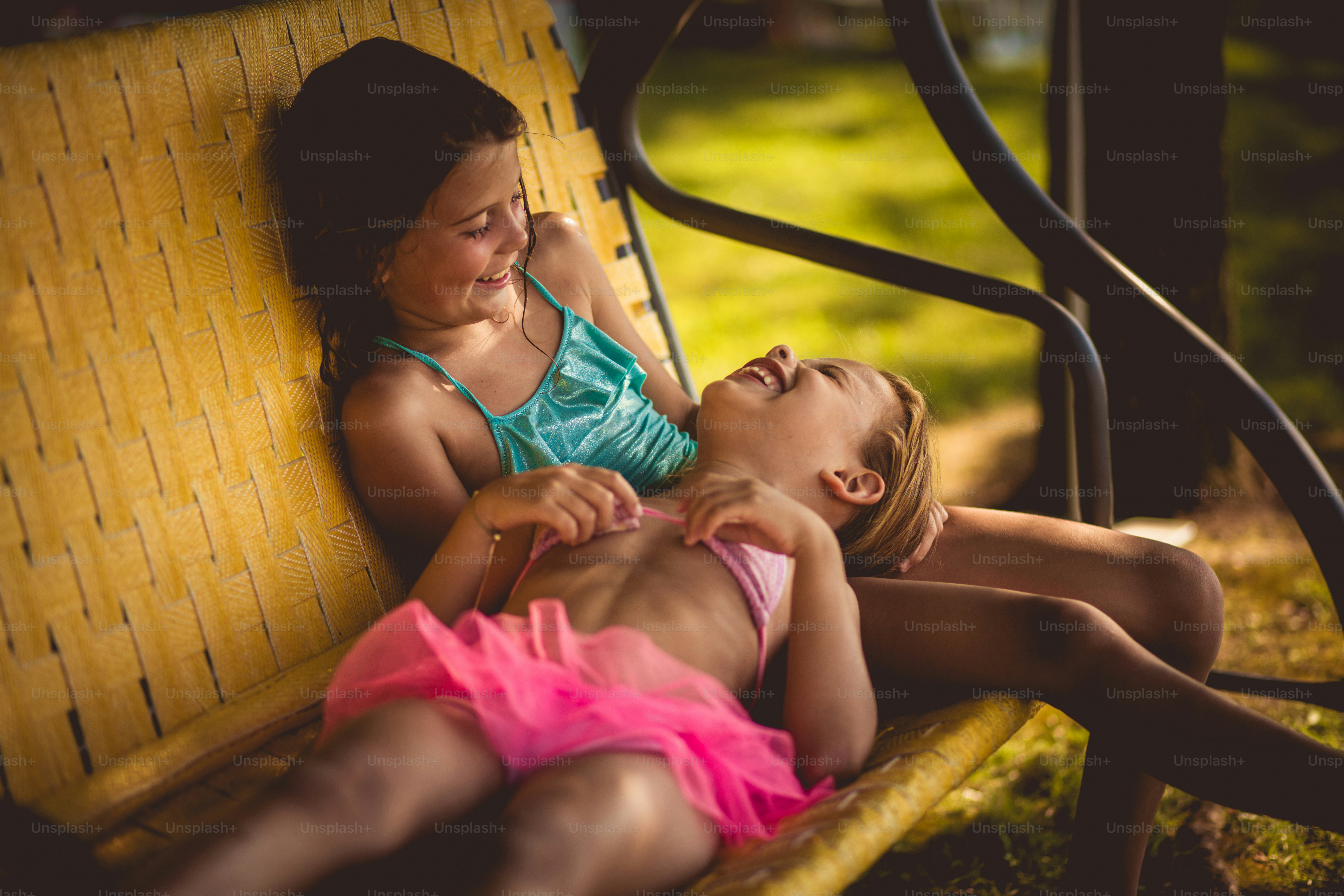 Forever together. Two little girl sitting on the bench