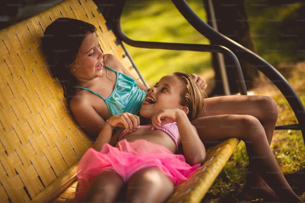 Sei immer deine Schwester und Freundin. Zwei kleine Mädchen sitzen auf der Bank