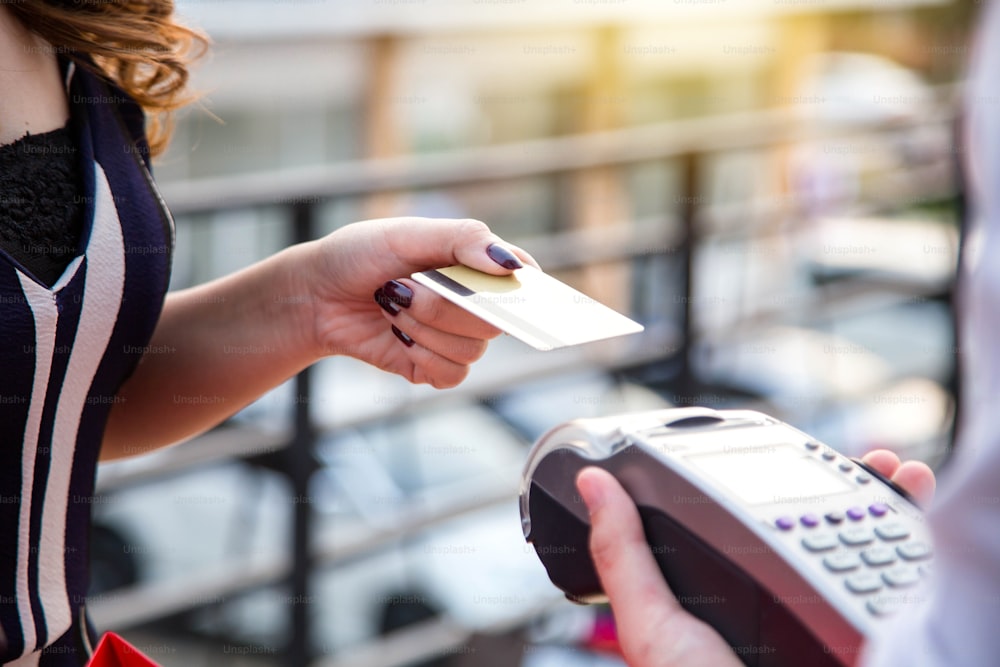 Woman payment via credit card swipe machine.