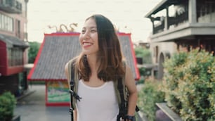 Mujer mochilera asiática que se siente feliz viajando en Beijing, China, alegre hermosa joven adolescente bloguera femenina caminando en Chinatown. Concepto de vacaciones de viaje turístico de mochila de estilo de vida.
