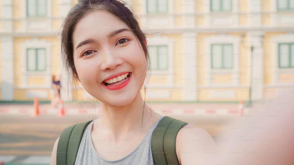 Asian blogger woman travel in Bangkok, Thailand, backpacker female using mobile phone make vlog and live in social media while spending sweet time in holiday trip. Women travel in city concept.