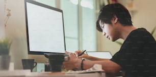 Young professional photographer editing his photo in creative workplace