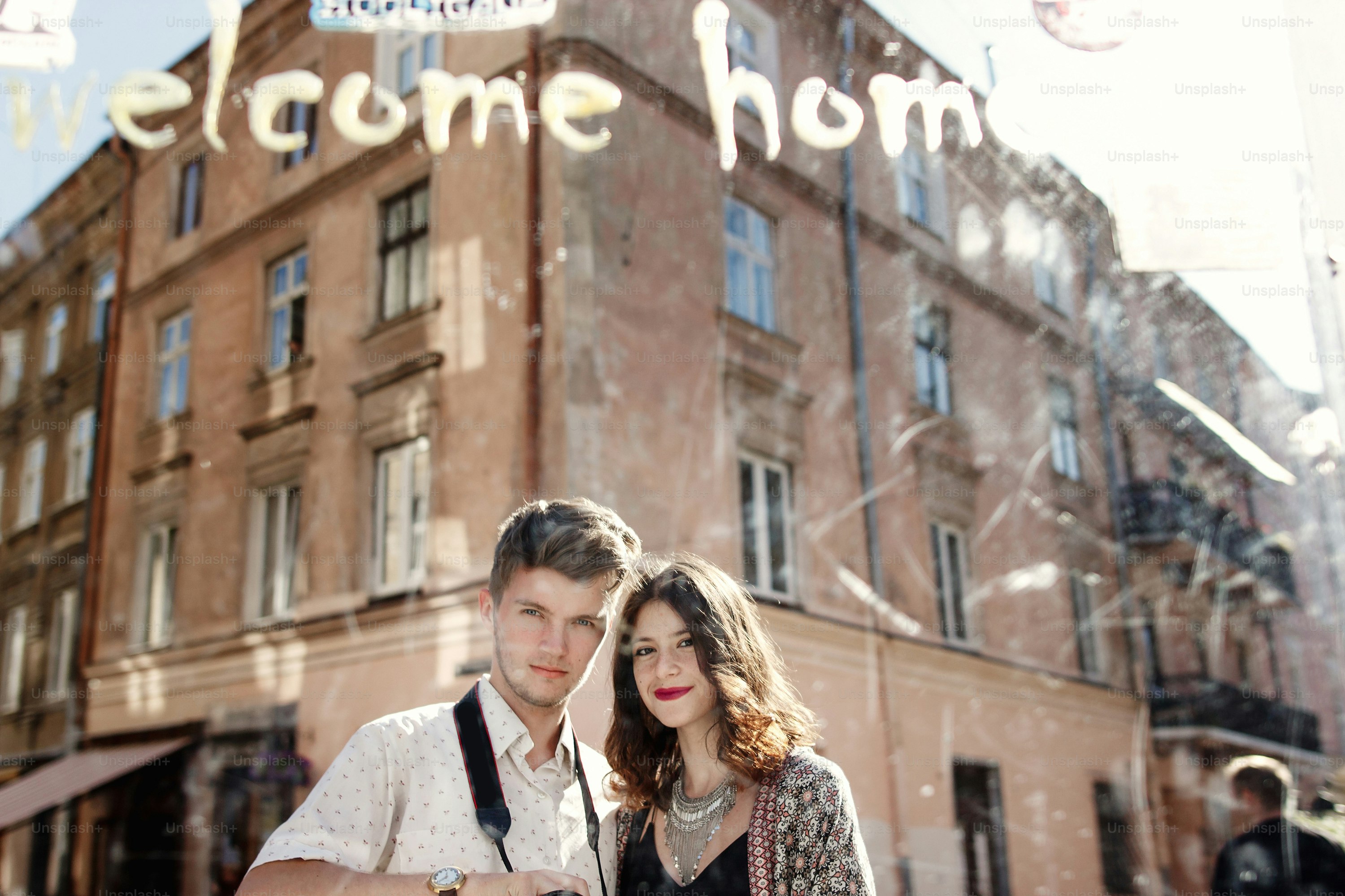 happy stylish couple taking selfie in a dirty mirror at old european city street, funny tender moment, space for text