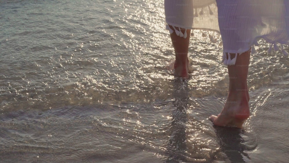 Young Asian woman walking on beach. Beautiful female happy relax walking on beach near sea when sunset in evening. Lifestyle women travel on beach concept.