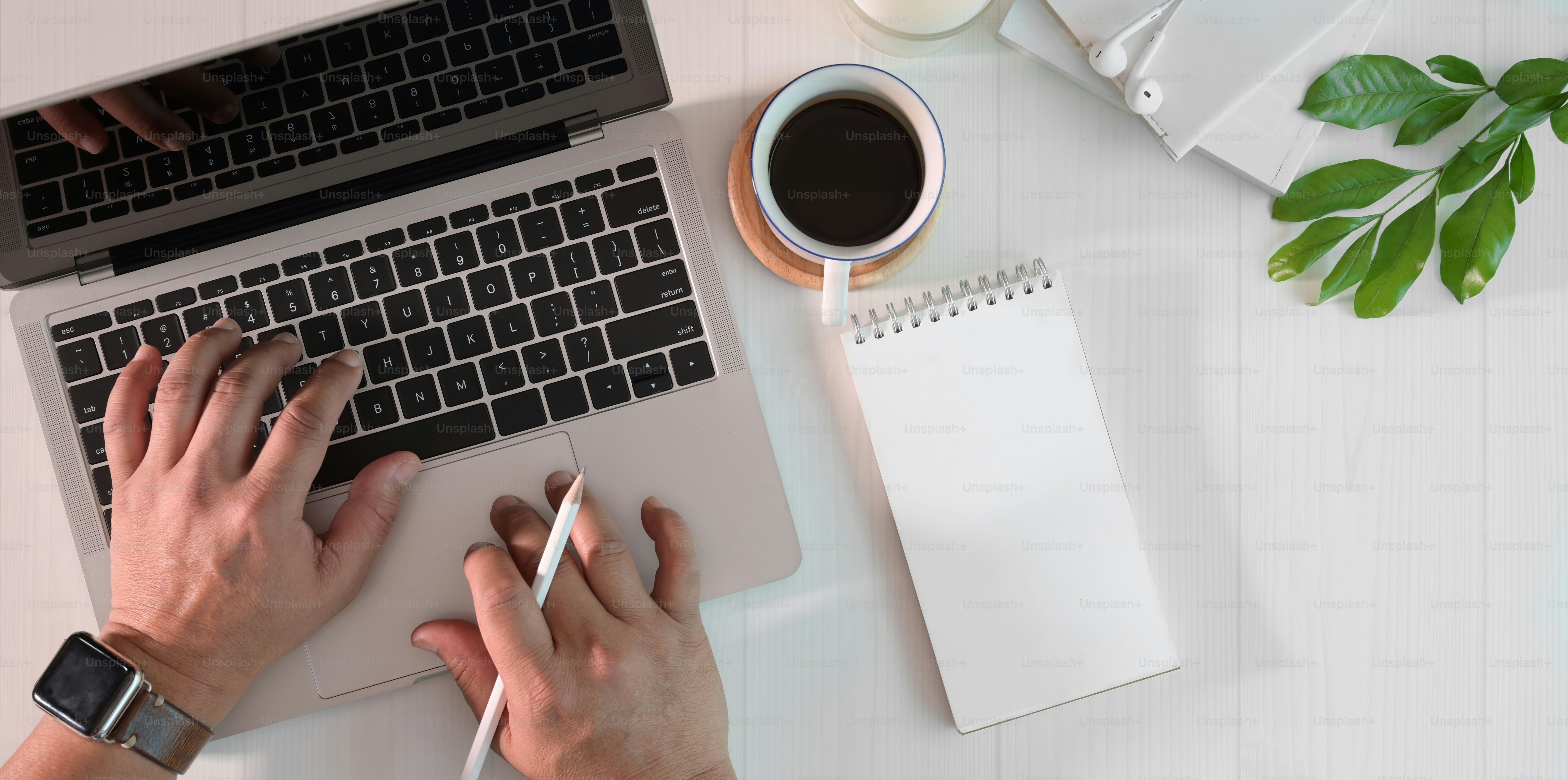 A person writing a blog on laptop with coffee, cozy workspace, modern minimal setup