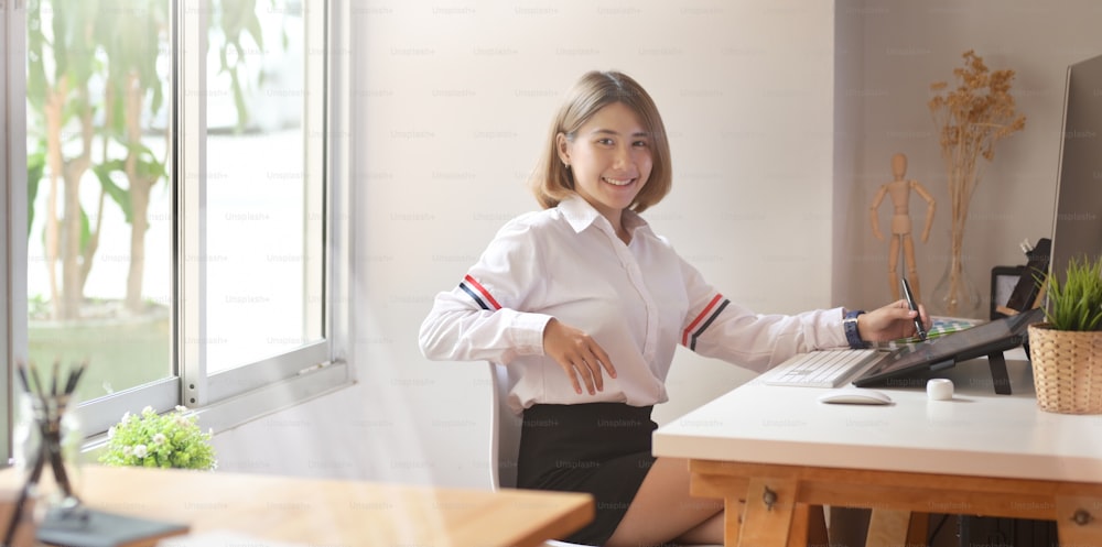 Confident Asian female freelancer at her workspace desk