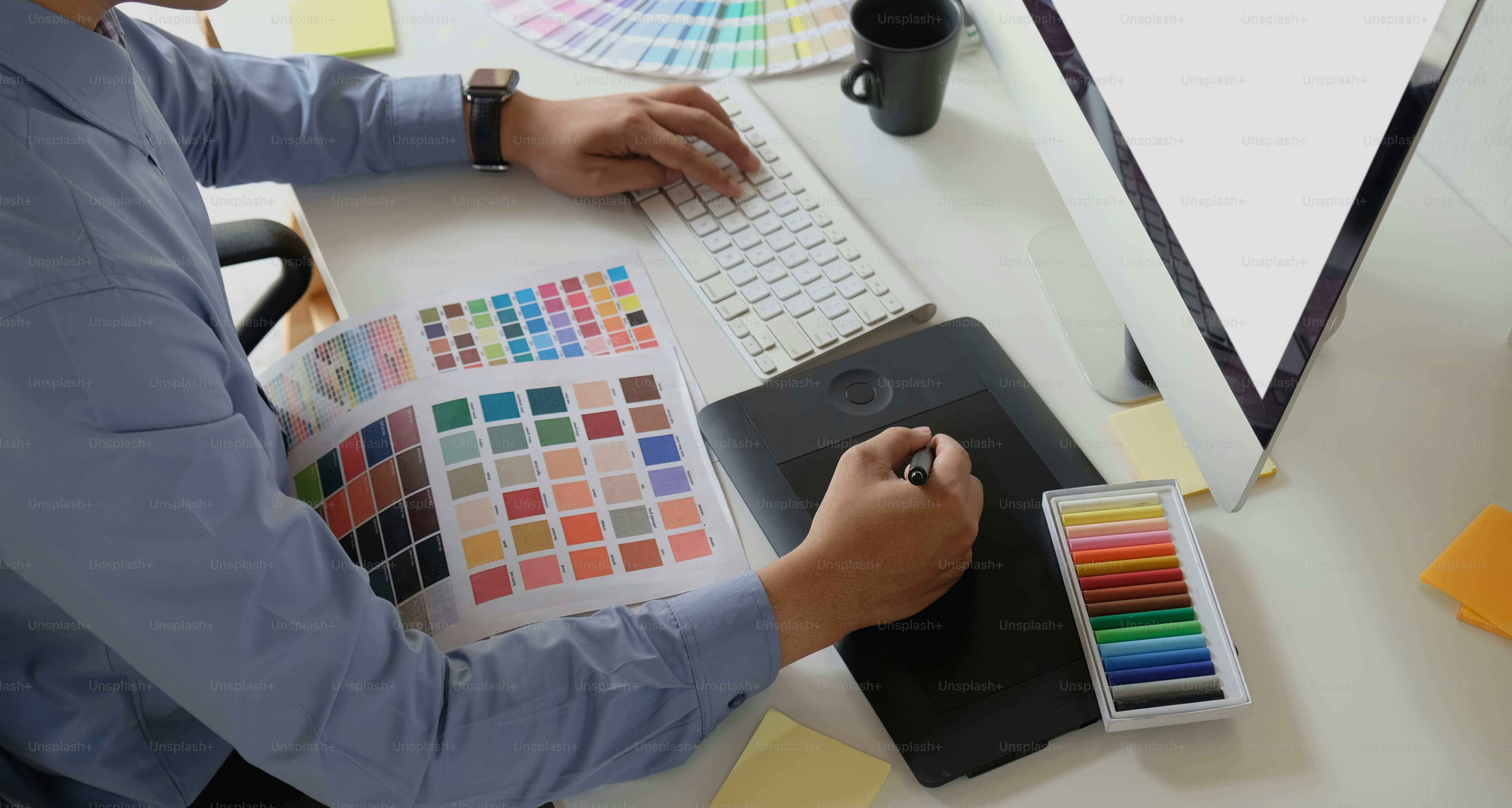 Graphic designer working with drawing tablet and colour swatches