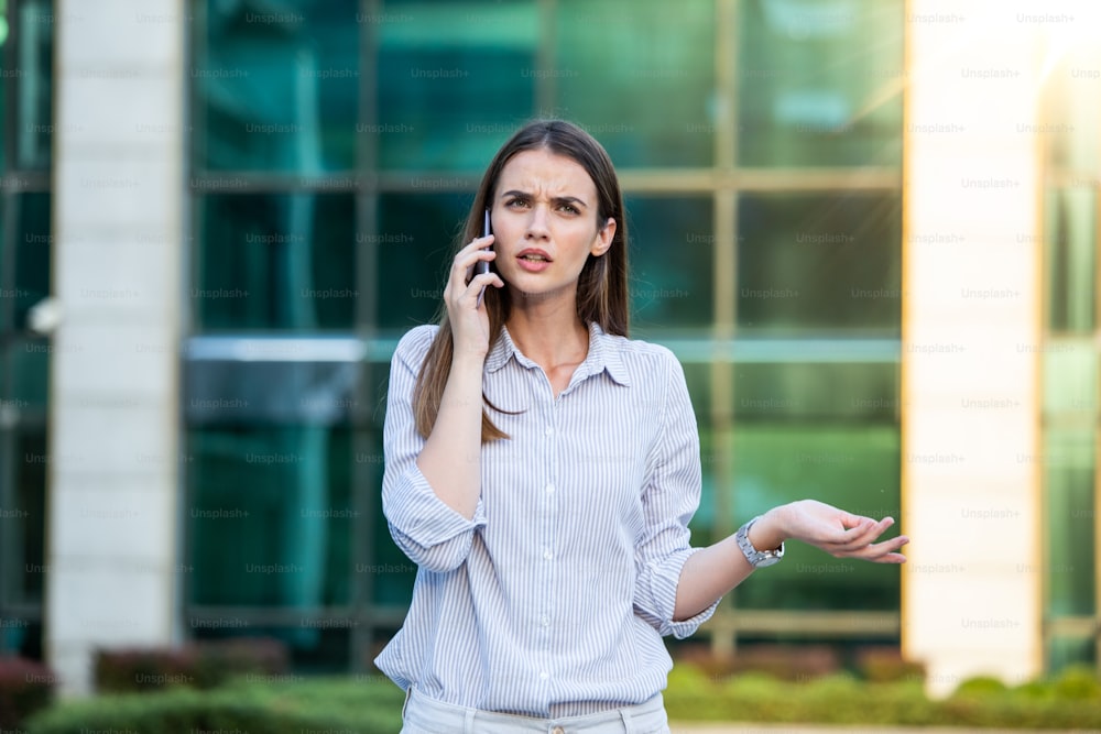 Businesswoman in formal wear having trouble with contracts talking on the phone and holding clipboard. Businesswoman angry abount about paperwork failure at workplace, executives having conflict