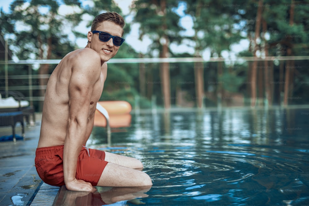 Caucasian man having a rest in the swimming pool. Summertime concept