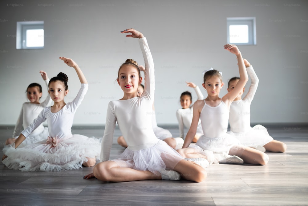 Little ballerinas in ballet studio. Group of girls exercising together