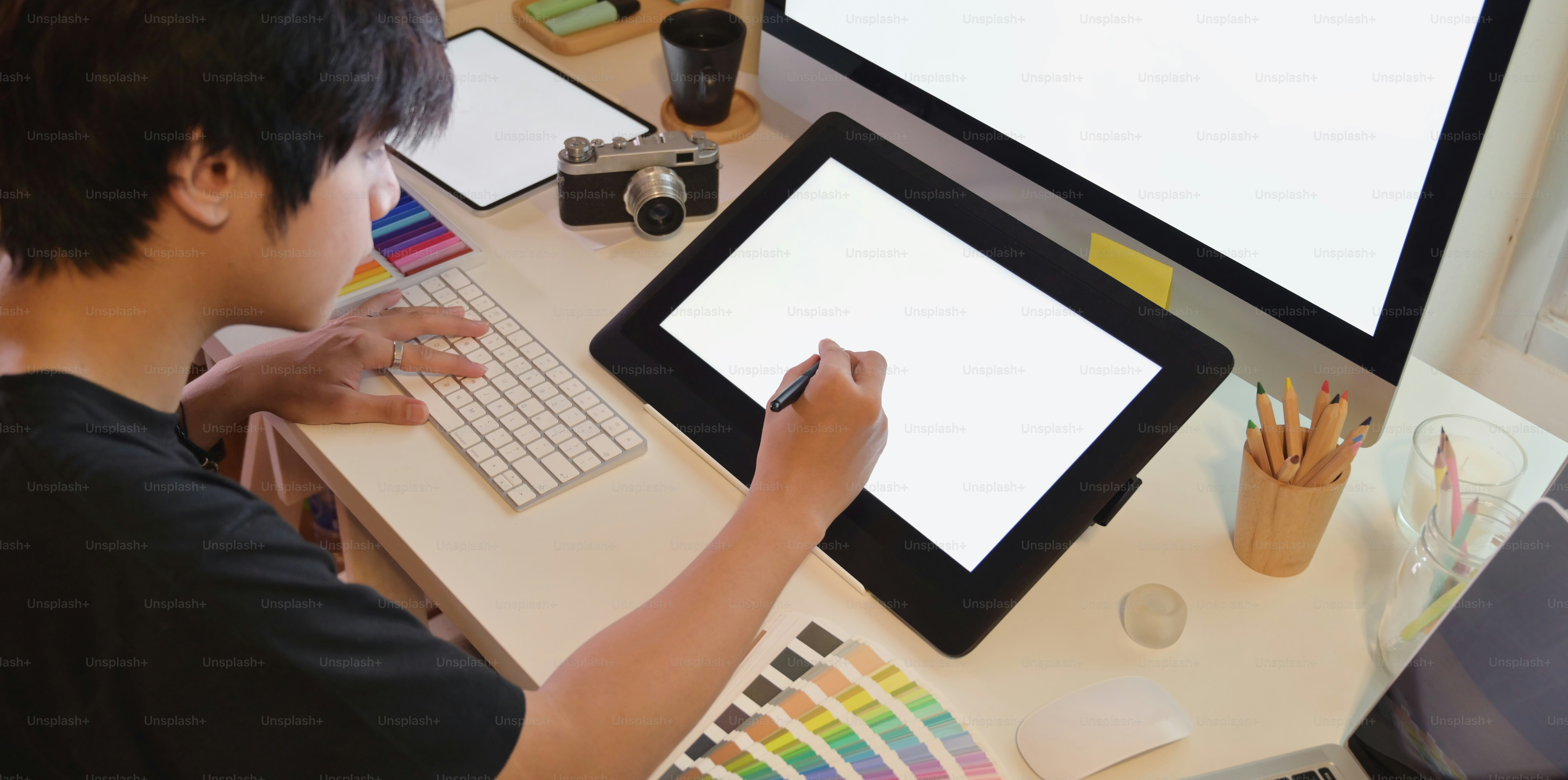Young professional photographer editing his project in graphic tablet ...