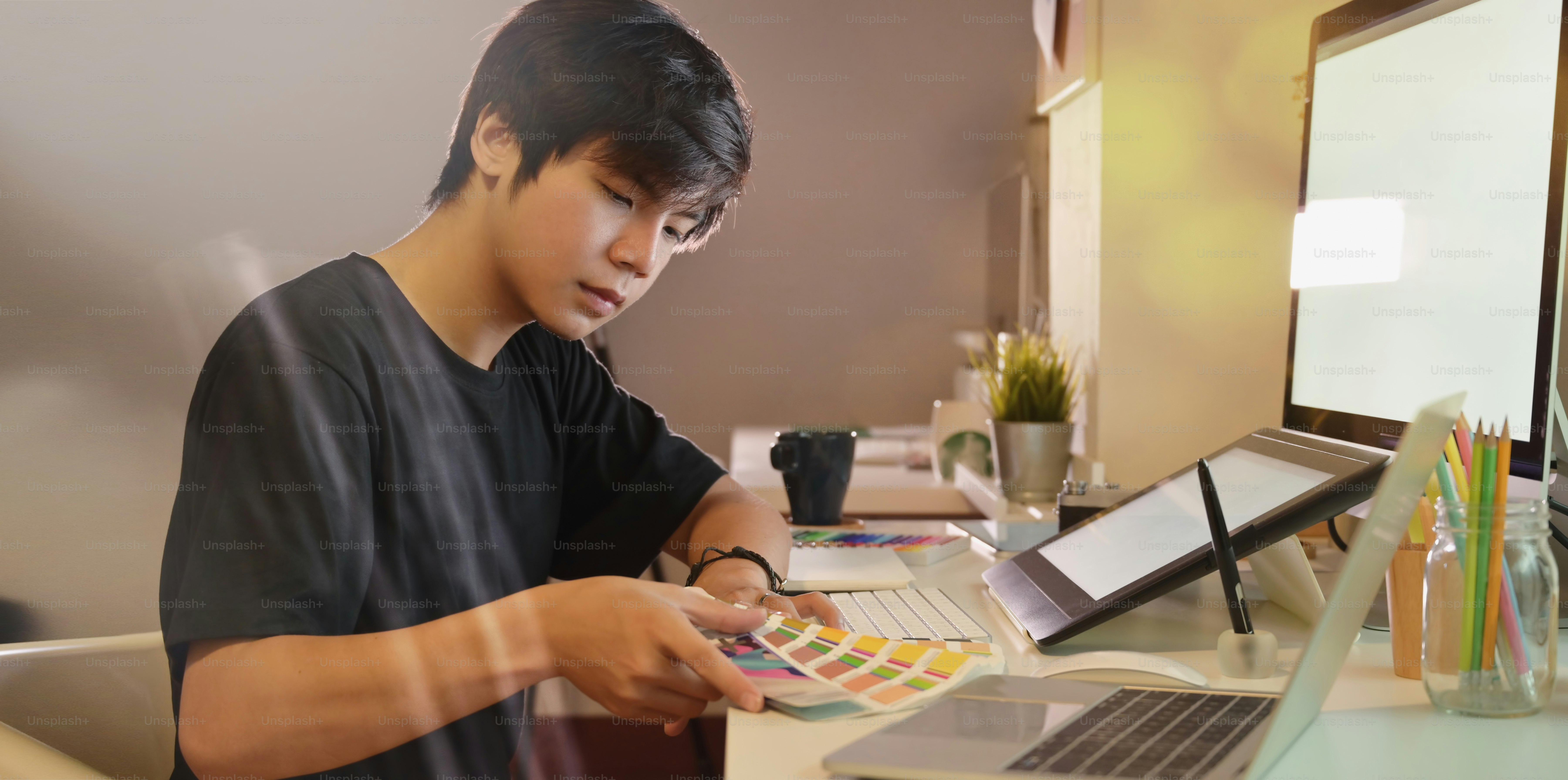 Young professional photographer working on his images with colour ...